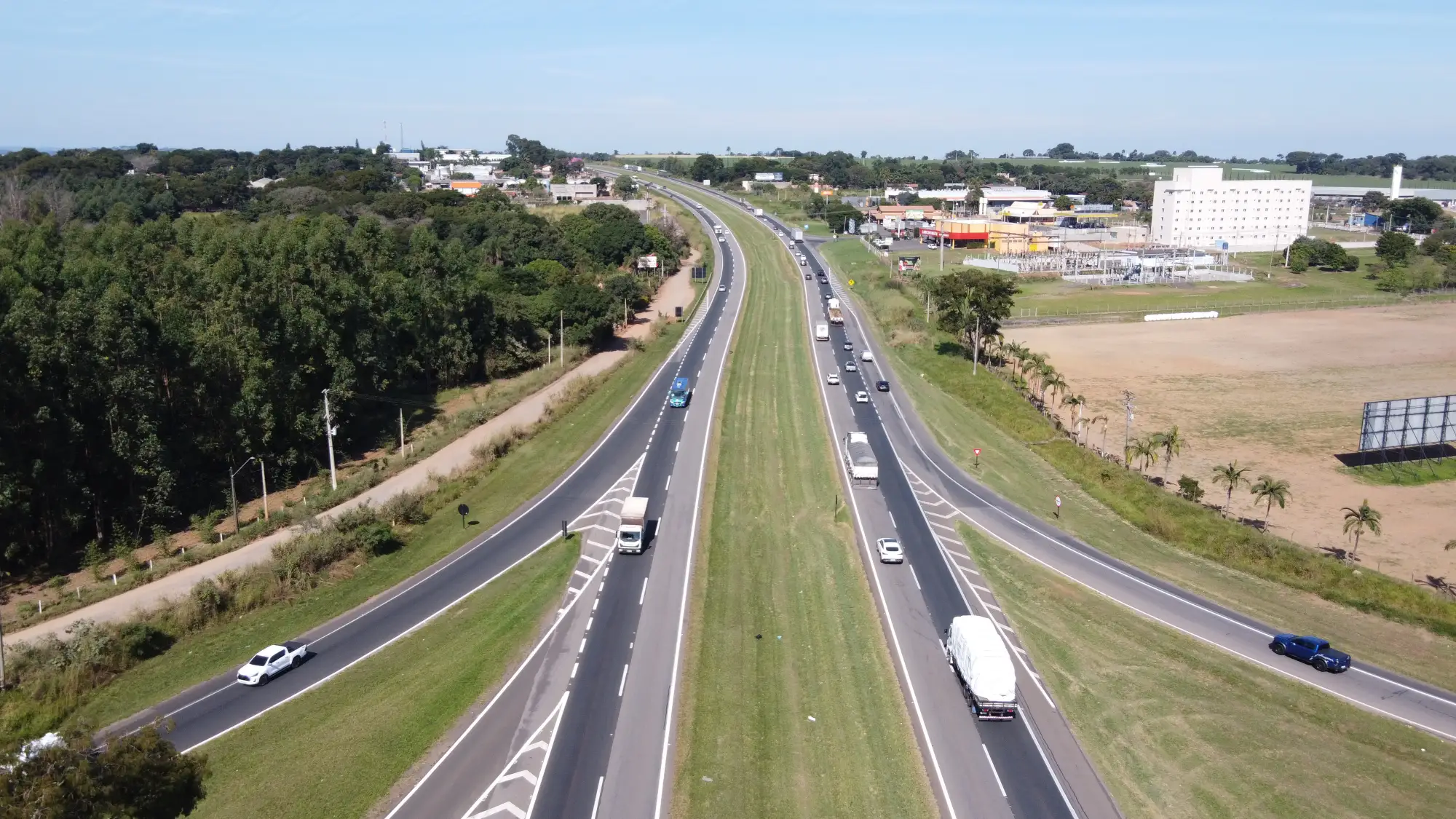 Trecho de rodovia duplicada com caminhões e carros